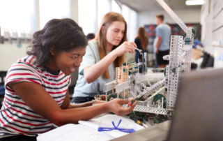 two teens building a robotics project