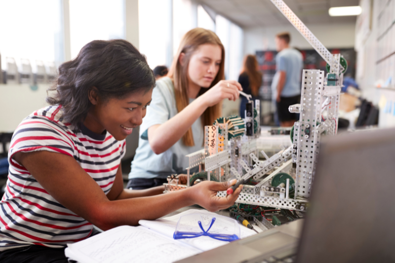 two teens building a robotics project