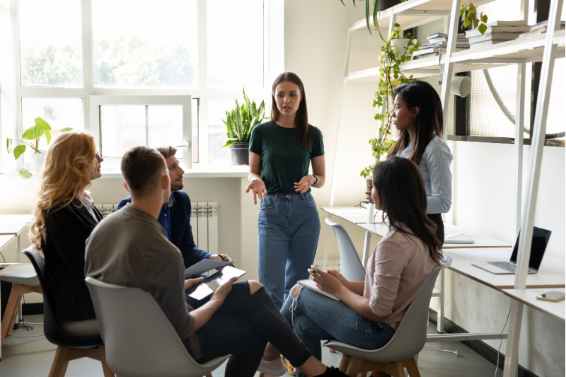 Group of people in a meeting discussing and reviewing organisational information together.