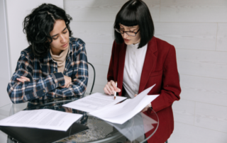 Two colleagues reviewing financial reports during year-end preparation for a New Zealand not-for-profit