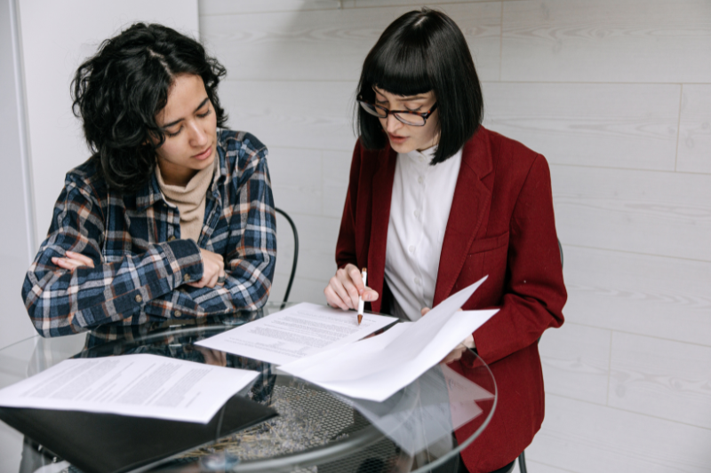 Two colleagues reviewing financial reports during year-end preparation for a New Zealand not-for-profit