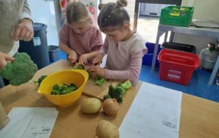 Girls chopping vegetables for a meal cooked at school, Garden to Table.